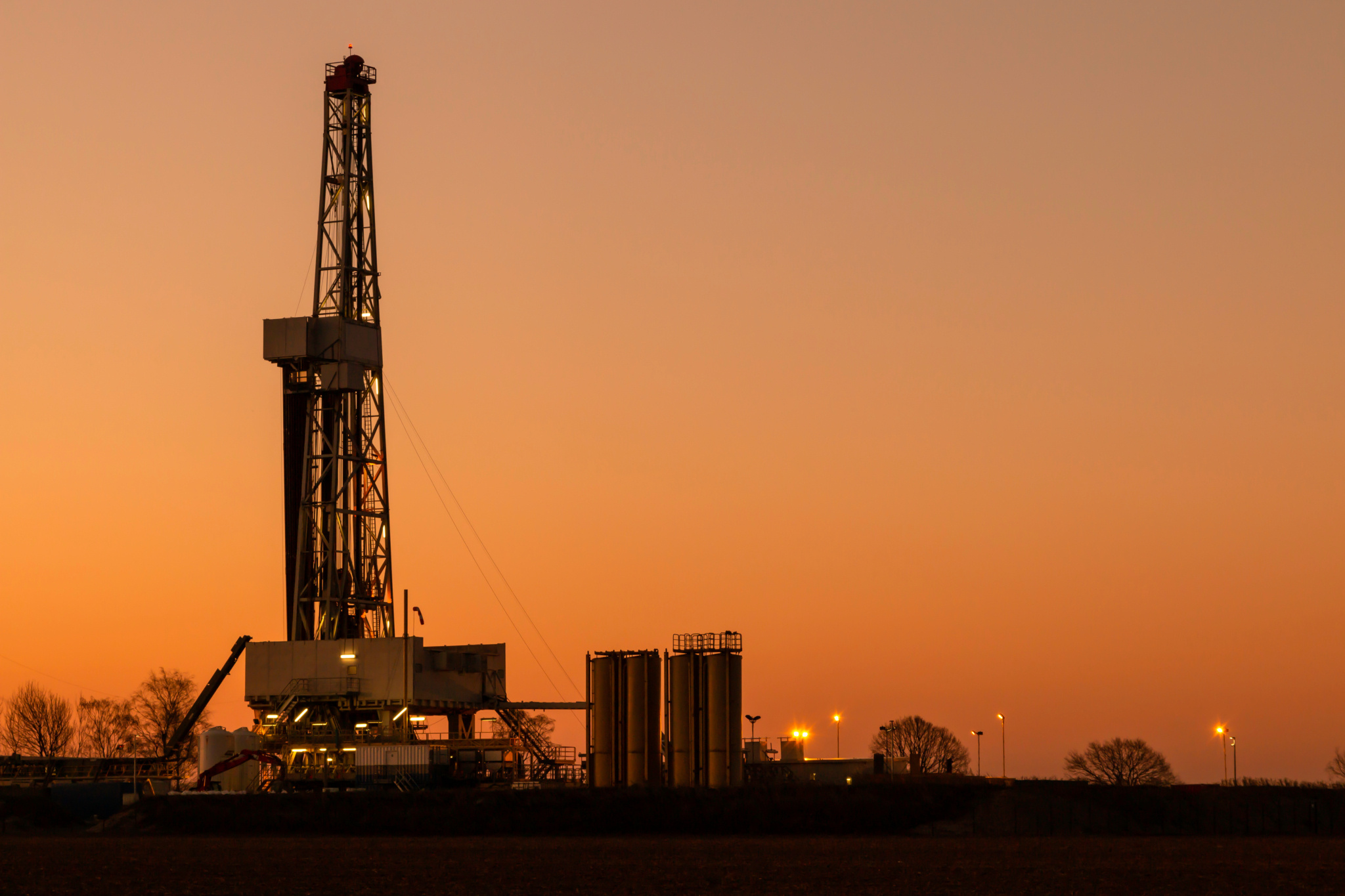 A land rig at sunset against an orange sky